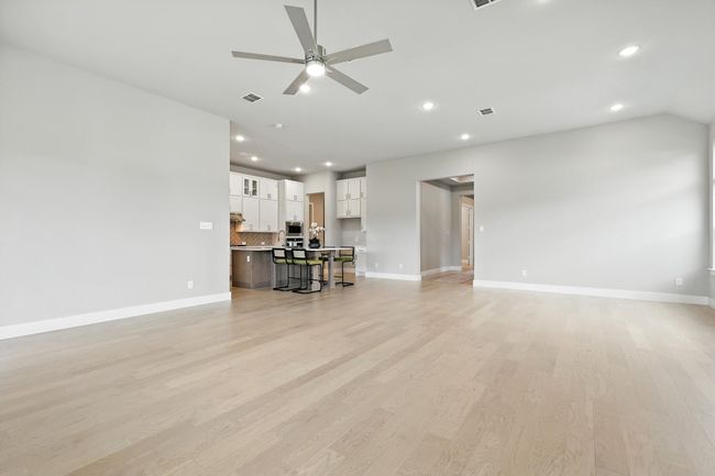 Living room with recessed lighting, a ceiling fan, light wood-type flooring, and vaulted ceiling | Image 9