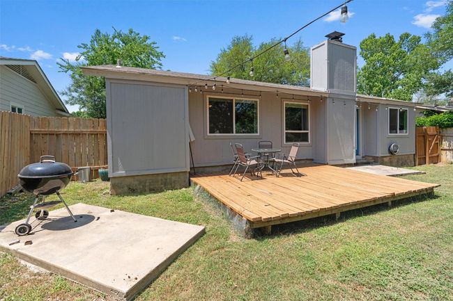 Rear view of house with a deck, a chimney, and a patio area | Image 31