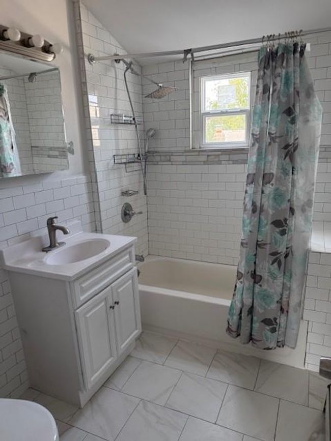Bathroom featuring vanity and shower / tub combo | Image 4