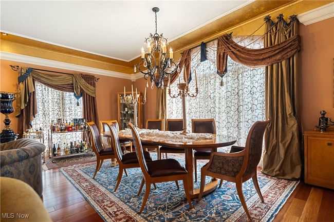 Dining space featuring hardwood / wood-style floors, a notable chandelier, and ornamental molding | Image 23