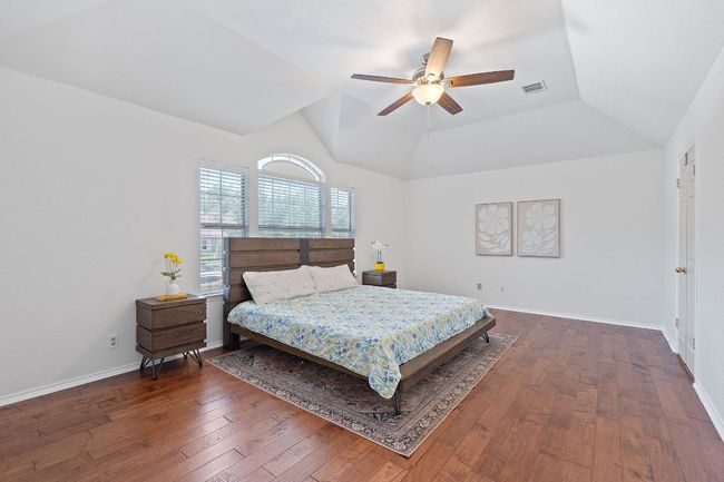 Bedroom featuring lofted ceiling, hardwood / wood-style flooring, and a ceiling fan | Image 17