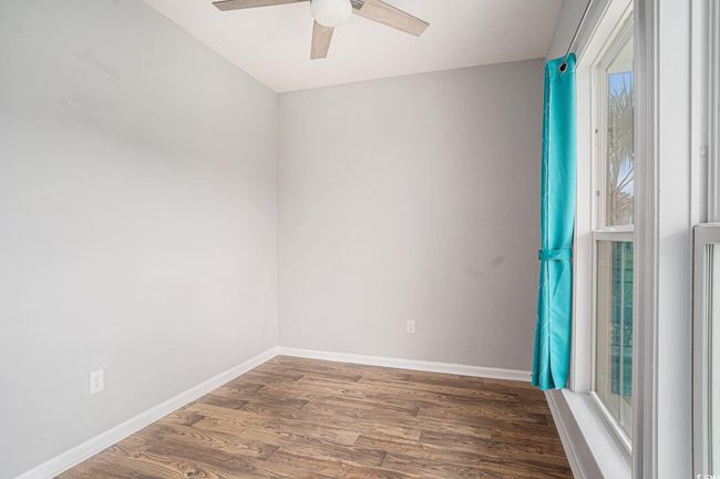 Empty room with a ceiling fan and wood finished floors | Image 27