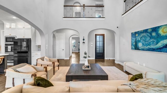Living area featuring baseboards, arched walkways, and wood finished floors | Image 6