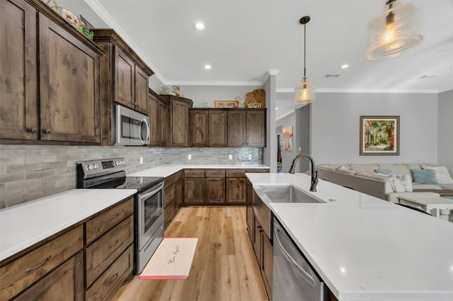 Kitchen with open floor plan, an island with sink, light wood-style flooring, appliances with stainless steel finishes, and a sink | Image 14