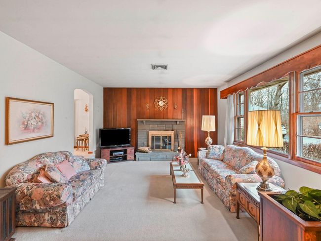 Carpeted living room with wooden walls | Image 13