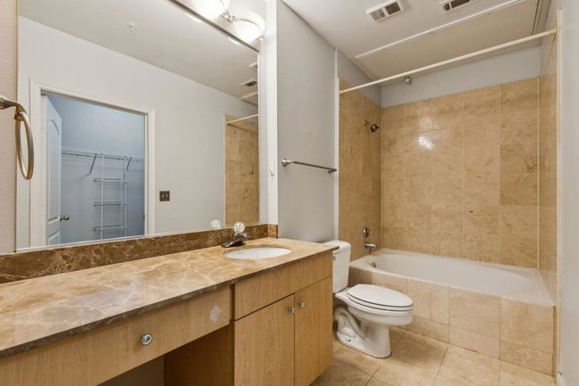 Full bath with tiled shower / bath, vanity, tile patterned floors, and a spacious closet | Image 17