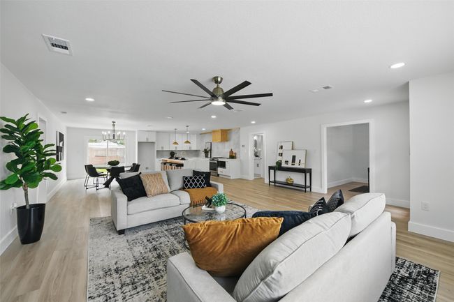 Living area featuring light wood finished floors, ceiling fan, baseboards, recessed lighting, and a​​‌​​​​‌​​‌‌​‌‌​​​‌‌​​‌‌​‌​​​​​‌ chandelier | Image 6
