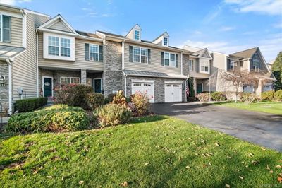 Townhome / multi-family property with a garage and a front lawn | Image 1