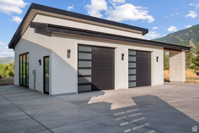 Garage featuring a mountain view and concrete driveway | Image 68