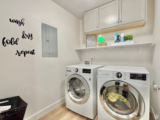 Laundry room featuring baseboards, washing machine and clothes dryer, light wood-style flooring, electric panel, and cabinet space | Image 11