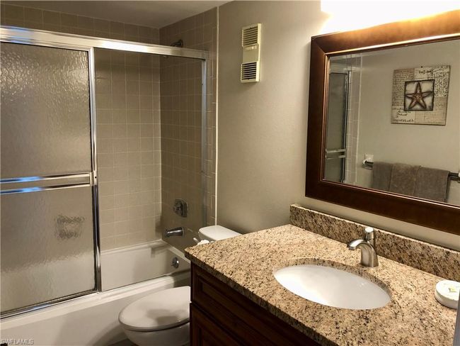Full bath featuring visible vents, enclosed tub / shower combo, toilet, and vanity | Image 15
