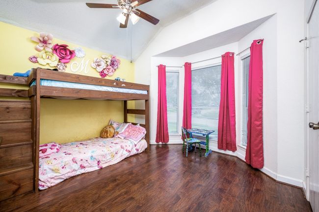 Bedroom with wood finished floors, vaulted ceiling, and ceiling fan | Image 12