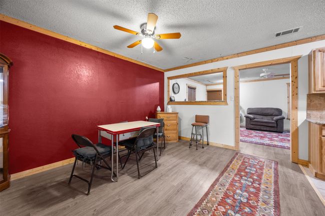 Dining space with wood finished floors, a ceiling fan. | Image 7