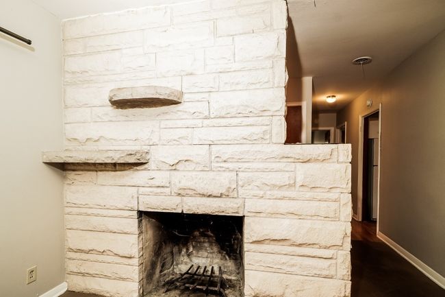 Detailed view of a fireplace and wood finished floors | Image 10