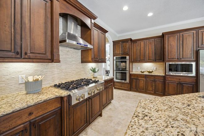 An upgraded Jenn Air 6 burner gas cooktop and exhaust, SS appliances, double oven, granite countertops, and brand new microwave. | Image 16