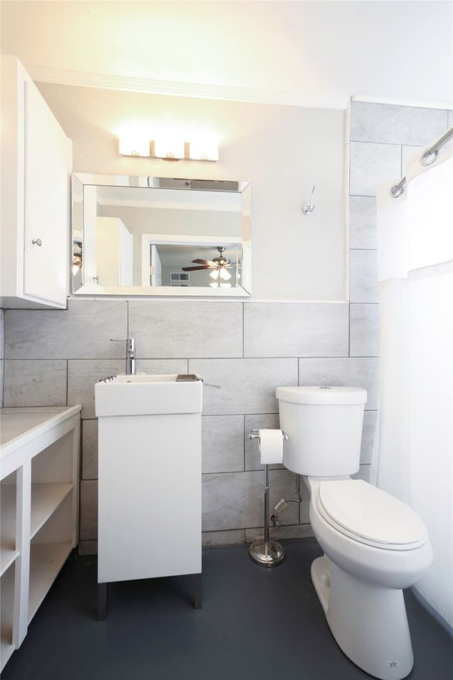 Bathroom featuring tile walls, vanity, ceiling fan, and a shower | Image 18