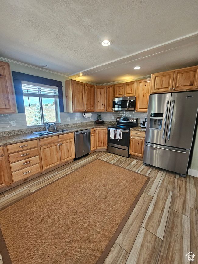 Kitchen featuring granite countertops, stainless steel appliances, recessed lighting, and backsplash | Image 30