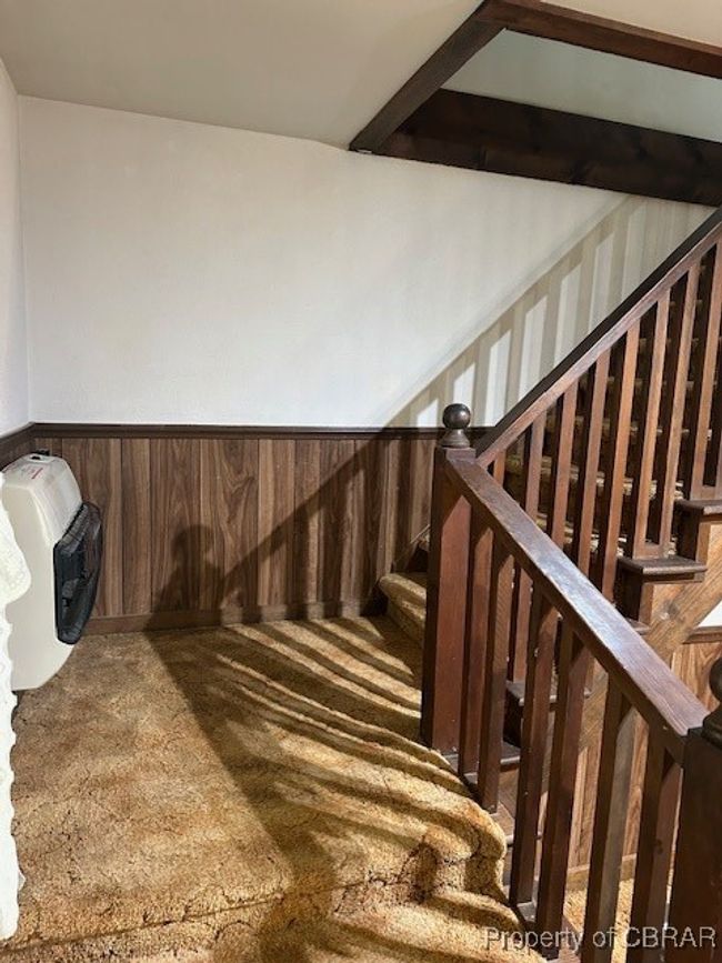 Stairway with carpet flooring, wainscoting, and heating unit | Image 15