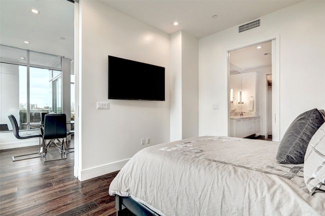Bedroom with dark wood finished floors, recessed lighting, and connected bathroom | Image 15