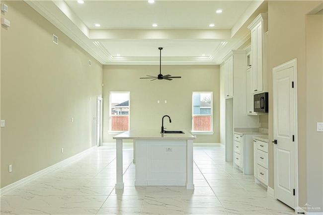 Kitchen with a healthy amount of sunlight, marble finish floor, and black microwave | Image 23