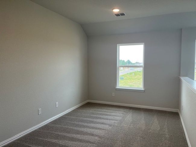 Empty room featuring dark colored carpet, plenty of natural light, and vaulted ceiling | Image 6