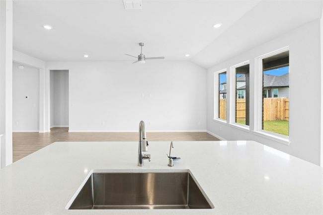 Kitchen featuring a sink, open floor plan, light countertops, recessed lighting, and vaulted ceiling | Image 8