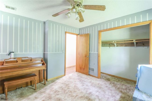 Bedroom with a ceiling fan, a closet, baseboards, and carpet flooring | Image 10