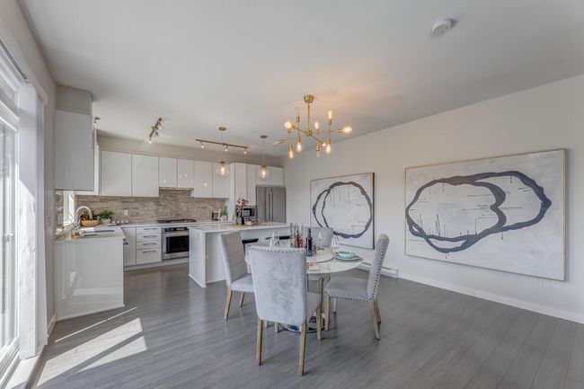 Dining area featuring a chandelier, dark wood-style floors, and track lighting | Image 8