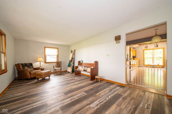 living area featuring wood finished floors, plenty of natural light, and baseboards | Image 9