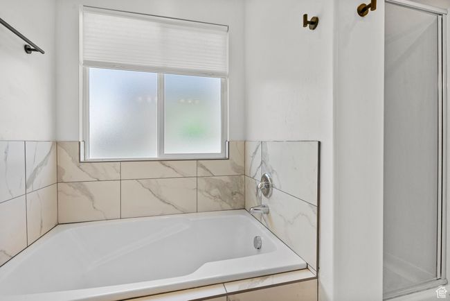 Bathroom featuring an enclosed shower and a tub to relax in | Image 12