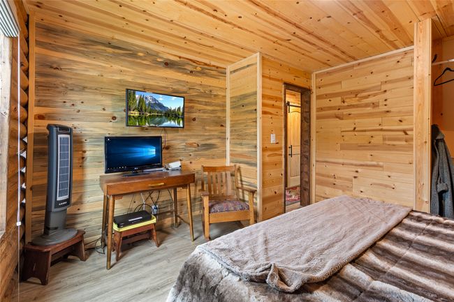 Bedroom featuring wooden ceiling, wooden walls, and wood finished floors | Image 16