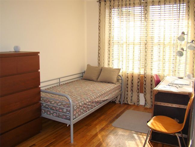 Bedroom with hardwood / wood-style flooring and a baseboard radiator | Image 10