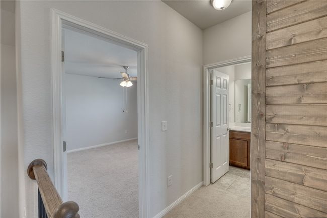 Hallway with light carpet and baseboards | Image 33