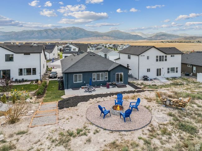 Rear view of house with a fire pit, a residential view, a patio area, a mountain view, and roof with shingles | Image 43
