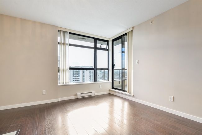 Unfurnished room featuring a baseboard radiator and dark wood finished floors | Image 5