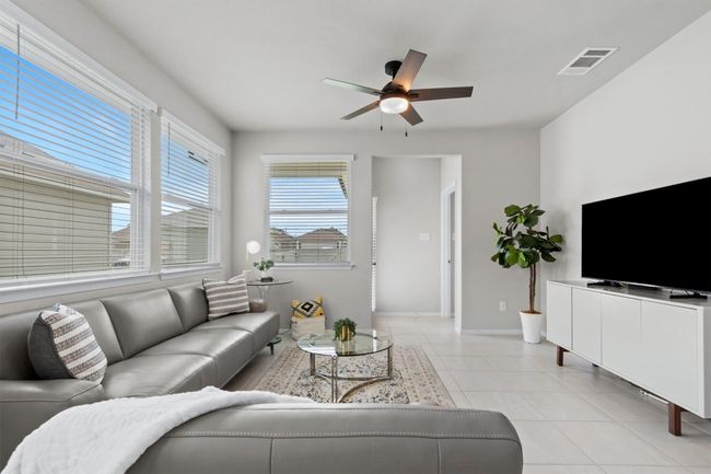 Living room with ceiling fan, baseboards, and light tile patterned floors | Image 7