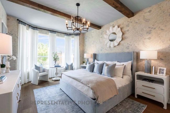 Bedroom featuring wallpapered walls, beamed ceiling, dark wood finished floors, and a chandelier | Image 14