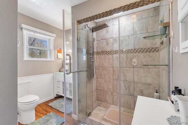 View of remodeled bathroom with new vanity, glass shower, flooring and toilet | Image 15