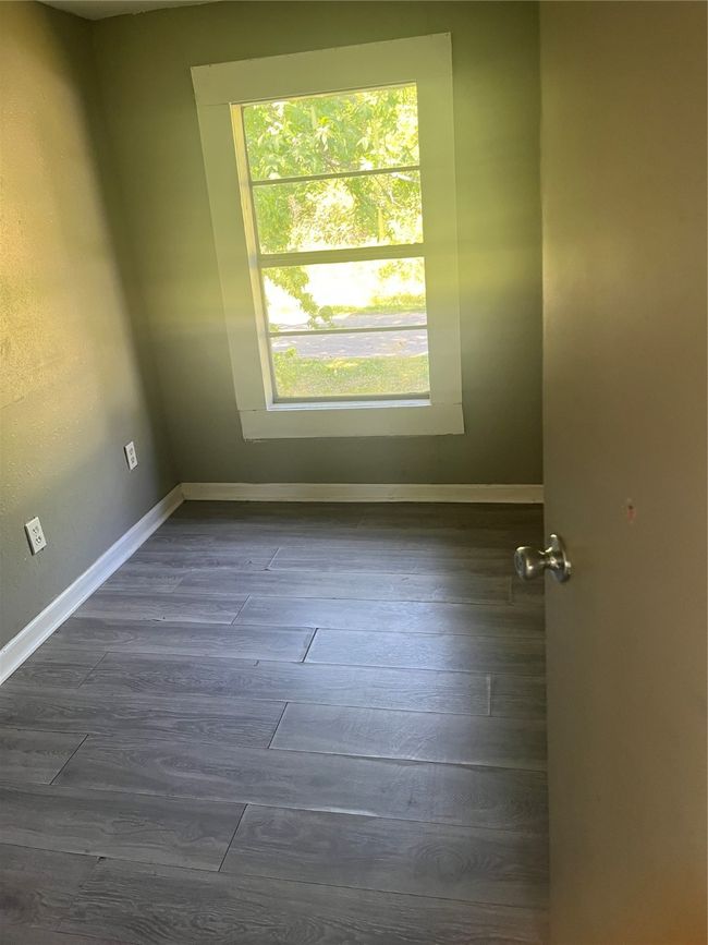 Spare room featuring baseboards and dark wood-type flooring | Image 11