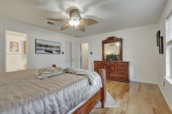 Bedroom with ceiling fan, ensuite bathroom, and light hardwood / wood-style flooring | Image 23