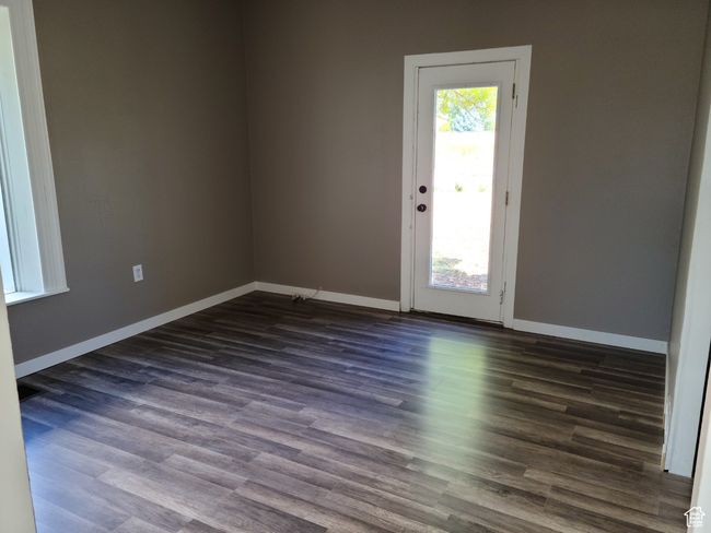 Spare room with dark wood-type flooring and baseboards | Image 17