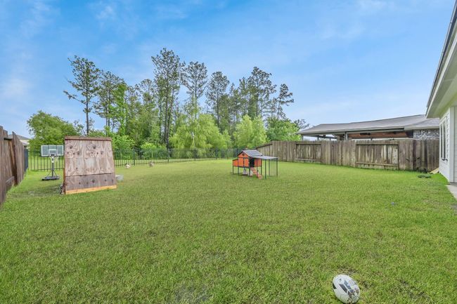The backyard offers a blend of leisure and lifestyle, with space for whatever your heart desires! Can you picture a pool here, playscape, expanded patio, etc? Whatever it is you'll enjoy this gorgeous greenbelt view along with the lake (just out of view from this angle.) | Image 33