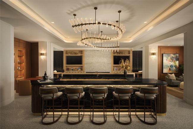 Indoor wet bar featuring built in features, a tray ceiling, and decorative light fixtures | Image 34