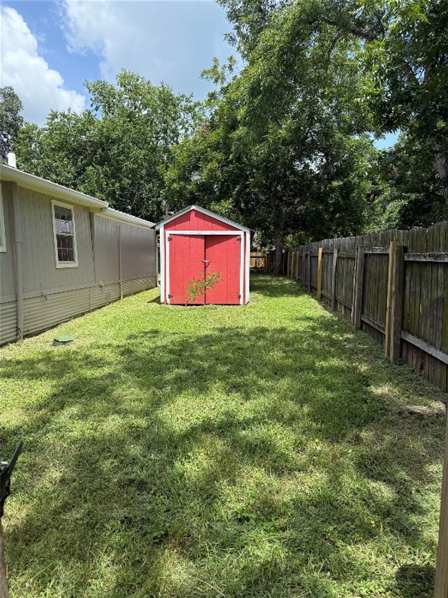 Fenced backyard featuring a storage shed | Image 13