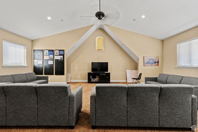 Carpeted living area featuring baseboards, a ceiling fan, lofted ceiling, and recessed lighting | Image 35