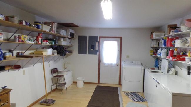 Shared laundry room with electric panels, light wood finished floors, washer and dryer, and laundry area | Image 21