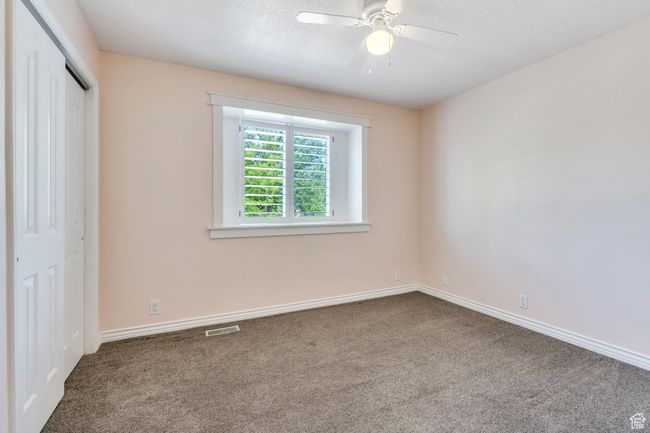 Unfurnished bedroom featuring carpet flooring, a closet, a ceiling fan, and a textured ceiling | Image 11