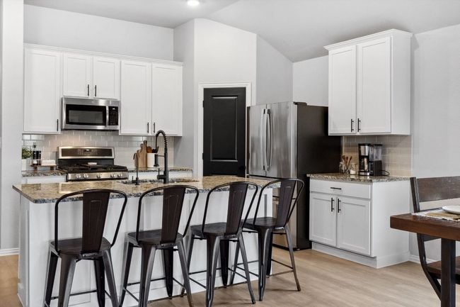 A large island offers a casual dining space. | Image 8