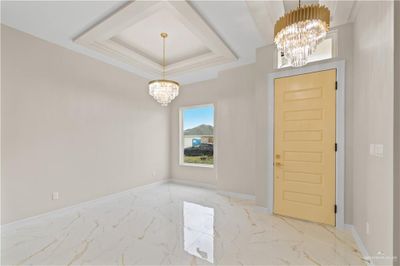 Foyer with a tray ceiling and a chandelier | Image 2