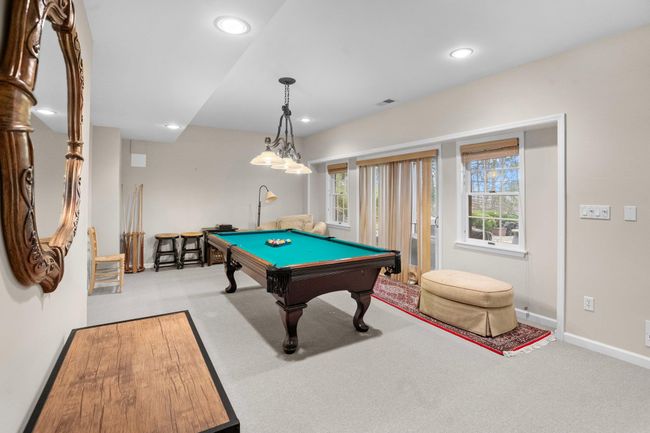The bright and open game room offers plenty of space for a pool table, lounging, and walk-out access to the backyard. | Image 37